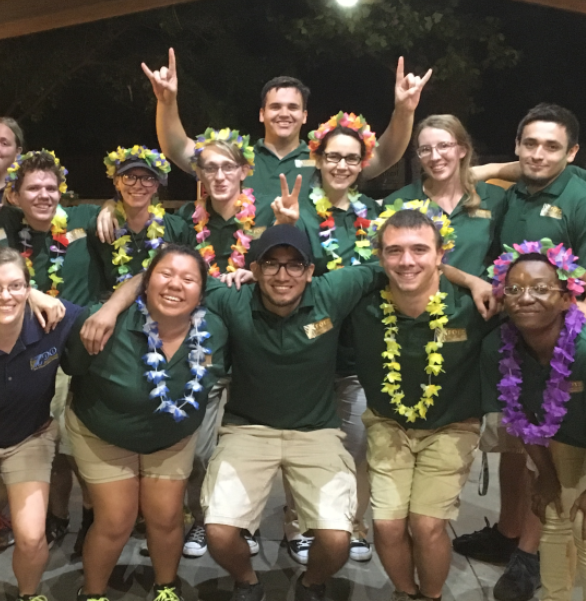 group of smiling employees wearing green polos and leis at Topeka Zoo