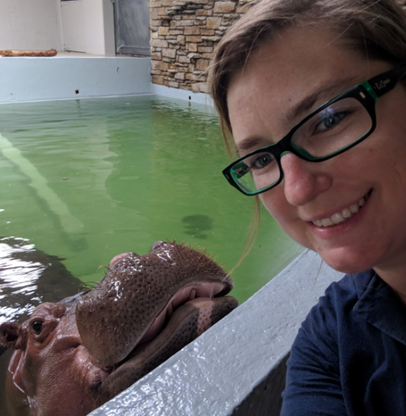 smiling woman with glasses taking a selfie with hippo at Topeka Zoo