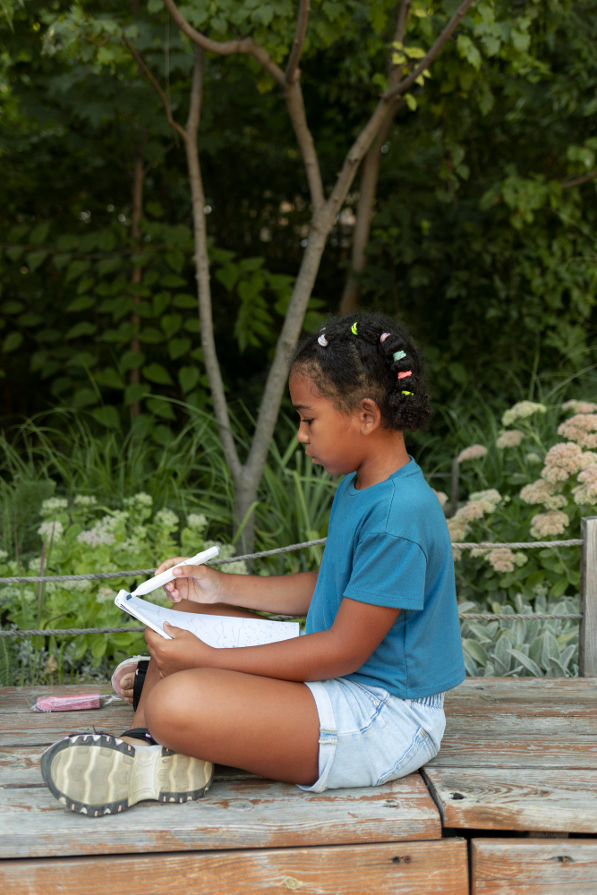 child writing at the zoo